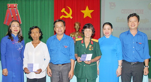    Lãnh đạo Tỉnh Đoàn Trà Vinh trao sổ tiết kiệm và chụp ảnh lưu niệm với các cựu thanh niên xung phong. Ảnh: BT